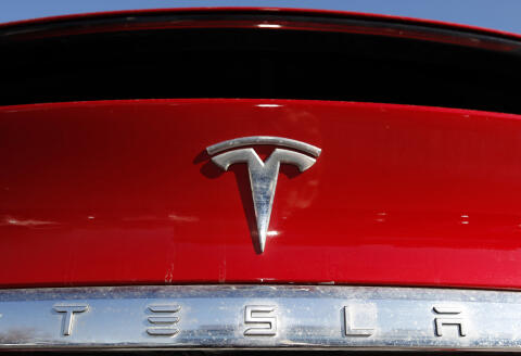 FILE - In this Feb. 2, 2020, file photo, the company logo appears on an unsold 2020 Model X at a Tesla dealership in Littleton, Colo. Tesla will split its stock for the first time in its history so more investors can afford to buy a stake in the electric car pioneer following a meteoric rise in its market value, the company announced Tuesday, Aug. 11, 2020. (AP Photo/David Zalubowski, File)