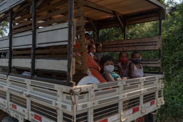 Des habitants de la réserve Chico Mendes dans une camionnette rustique, leur principal moyen de transport public, au Brésil, le 30 juillet.
