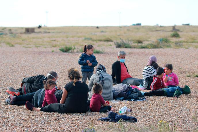 Un groupe de migrants se repose sur la plage en attendant les responsables des forces frontalières britanniques à Dungeness, dans le sud de l’Angleterre, le 6 août.