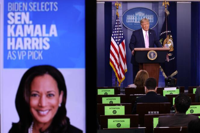 Le président Donald Trump, le 11 août, à la Maison Blanche, alors qu’une photo de la sénatrice Kamala Harris est diffusée sur un écran.