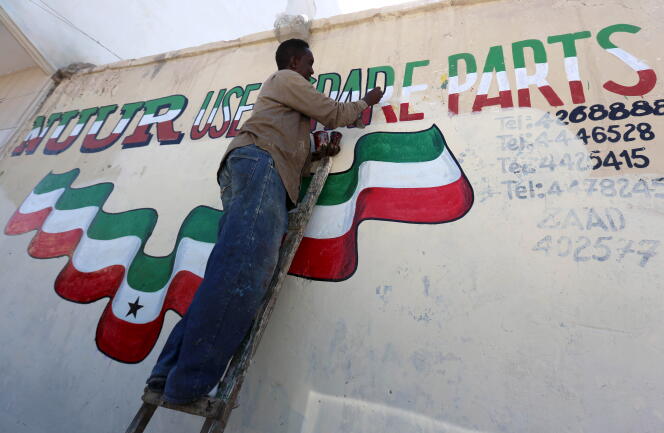 Un homme peint une publicité aux couleurs du Somaliland sur un mur de la capitale, Hergeisa, en mai 2015.