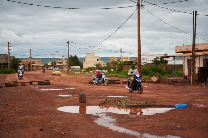 People ride their scooters on the rough road between Kati, 15 km northwest of Bamako, and the western city of Kayes, on August 27, 2019. 