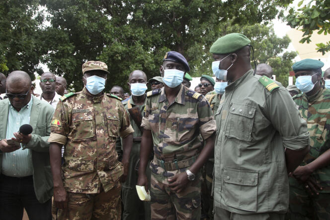 Le colonel-major Ismaël Wagué, chef d’état-major adjoint de l’armée de l’air (au centre), entouré de soldats mutinés, le 19 août à Kati, au Mali.