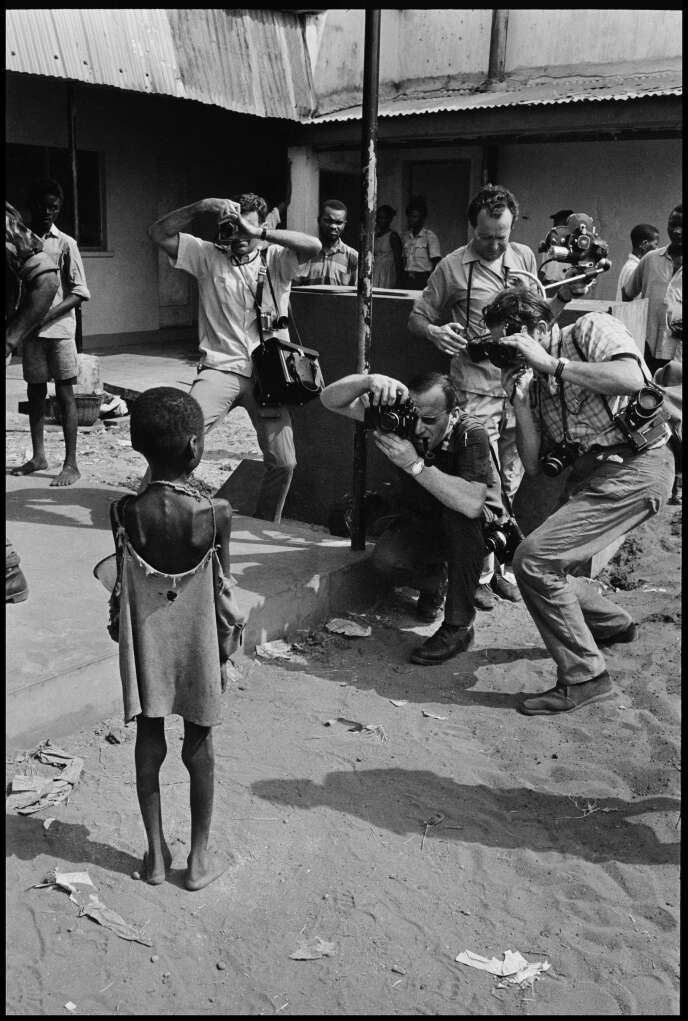 Des photographes occidentaux prennent en photo un enfant qui souffre de malnutrition à cause de la guerre du Biafra, à Owerri, en 1970.