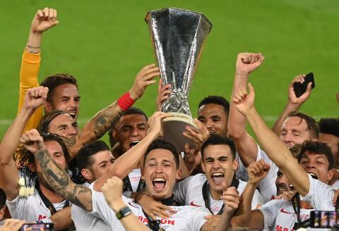 Sevilla's players celebrate with the trophy after winning the UEFA Europa League final football match Sevilla v Inter Milan on August 21, 2020, in Cologne, western Germany. / AFP / POOL / Ina Fassbender 