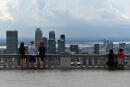 People are seen at Mont Royal Belvedere, with downtown Montreal, Canada on the background on July 29, 2020. - Stripped of the crowds of visitors that usually flock to its sights, from the Grand Prix to its renowned festivals, Montreal is trying to reinvent itself during the coronavirus pandemic and salvage what is left of its summer. (Photo by Eric THOMAS / AFP)