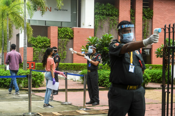 Des agents de sécurité privés vérifient la température corporelle des étudiants avant l’examen d’entrée à l’université hindoue de Bénarès (BHU), à Calcutta, le 27 août 2020.
