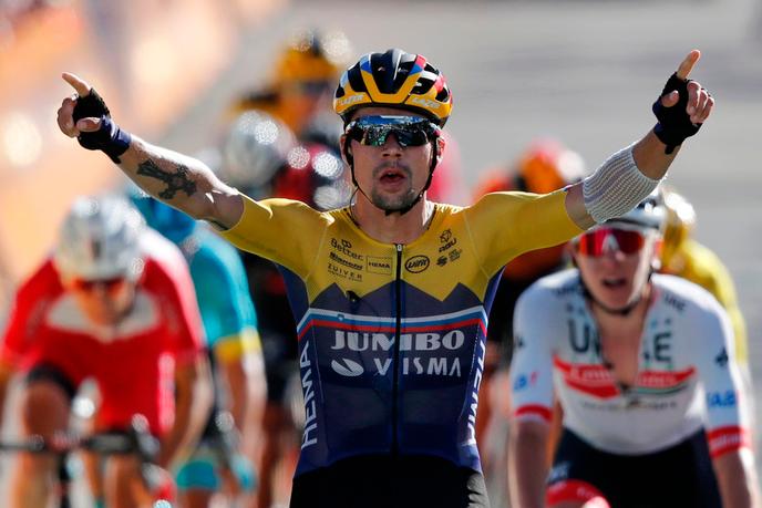 Primoz Roglic lèves les bras, derrière, son compatriote Tadej Pogacar regarde son aîné célébrer sa victoire.