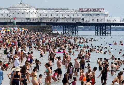 People enjoy the sunny weather on the beach, amid the coronavirus disease (COVID-19) outbreak, in Brighton, Britain August 8, 2020. REUTERS/Toby Melville TPX IMAGES OF THE DAY