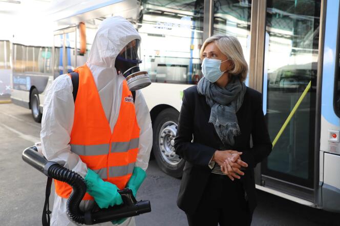 Valérie Pécresse en compagnie d’un employé chargé de désinfecter un bus, à Paris, le 2 septembre.