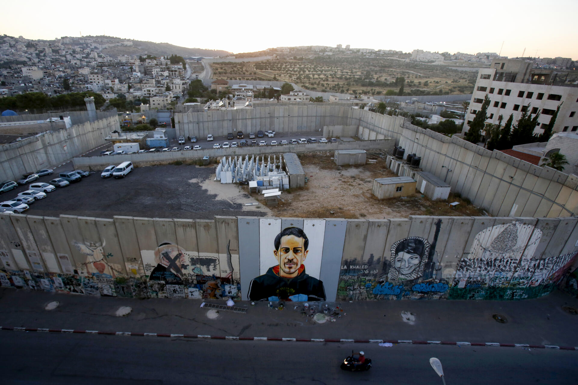 L’artiste Taqi Spateen réalise une peinture murale du Palestinien abattu par la police israélienne, sur une section du mur, à Bethléem, le 14 juin.