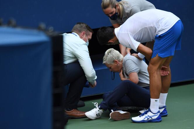 Novak Djokovic est auprès de la juge de ligne qui vient d’être percutée par la balle qu’il a lancée, à Flushing Meadows (New York), le 6 septembre.