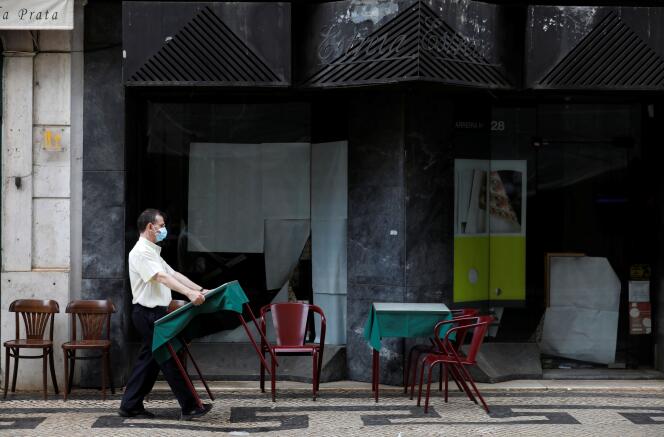 Un serveur installe des tables et des chaises dans la rue, en pleine épidémie de Covid-19, à Lisbonne, au Portugal, le 10 septembre 2020.