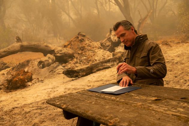 Le gouverneur, Gavin Newsom, signe un projet de loi après avoir visité une zone incendiée près d’Oroville, dans le comté de Butte, en Californie, le 11 septembre.