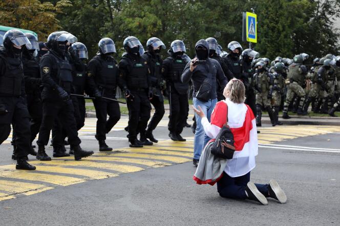 Une manifestante biélorusse s’agenouille devant les forces de l’ordre, à Minsk, dimanche 13 septembre.
