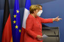 German Chancellor Angela Merkel (L) and French President Emmanuel Macron (R) step onstage for a joint press conference at the end of the European summit at the EU headquarters in Brussels on July 21, 2020. - EU leaders approved a 750-billion-euro package to revive their coronavirus-ravaged economies after a tough 90-hour summit on July 21, along with a trillion-euro budget for the next seven years. (Photo by JOHN THYS / POOL / AFP)