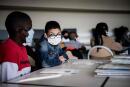 Pupils wearing a protective mask sit in a classroom in a middle school in Bron, on September 1, 2020, on the first day of the school year amid the Covid-19 epidemic. French pupils go back to school on September 1 as schools across Europe open their doors to greet returning pupils this month, nearly six months after the coronavirus outbreak forced them to close and despite rising infection rates across the continent. / AFP / JEFF PACHOUD
