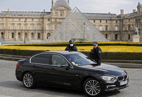 A car driver is controlled by police officers in front of the Louvre Museum in Paris on April 2, 2020 on the seventeenth day of a strict lockdown in France to stop the spread of COVID-19 (novel coronavirus). (Photo by THOMAS COEX / AFP)