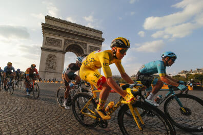Slovenia's Tadej Pogacar, wearing the overall leader's yellow jersey, rides past the Arc de Triomphe on the Champs-Elysees during the twenty-first and last stage of the Tour de France cycling race over 122 kilometers (75.8 miles), from Mantes-la-Jolie to Paris, France, Sunday, Sept. 20, 2020. (AP Photo/Christophe Ena)
