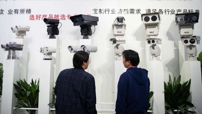 Des visiteurs regardent des caméras de reconnaissance faciale lors d’une exposition à Pékin, en Chine, en octobre 2018.