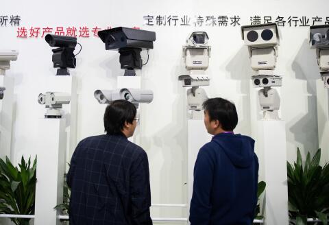 Visitors look at AI (artificial intelligence) security cameras using facial recognition technology at the 14th China International Exhibition on Public Safety and Security at the China International Exhibition Center in Beijing on October 24, 2018. (Photo by NICOLAS ASFOURI / AFP)