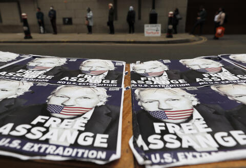 People queue at the entrance of the Old Bailey court in London, Monday, Sept. 21, 2020, as the Julian Assange extradition hearing to the US continues. (AP Photo/Frank Augstein)