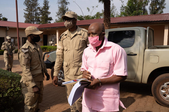 Le héros d’« Hôtel Rwanda », Paul Rusesabagina (en uniforme rose de détenu), arrive de la prison de Nyarugenge avec des agents du service correctionnel du Rwanda (RCS), à la cour de justice du district de Nyarugenge, à Kigali, le 25 septembre 2020.
