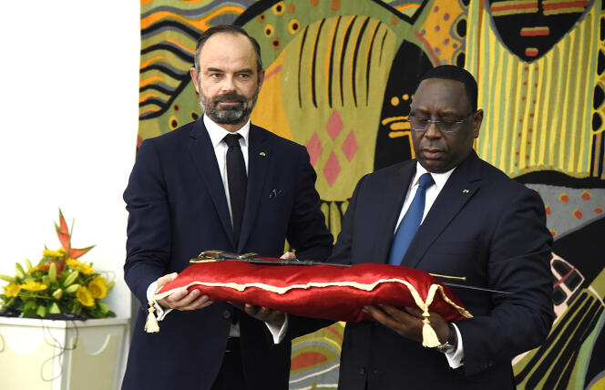 Le président du Sénégal Macky Sall (à droite) reçoit le sabre dit d’El Hadj Omar Tall des mains du premier ministre français Edouard Philippe au palais de la République à Dakar, le 17 novembre 2019.