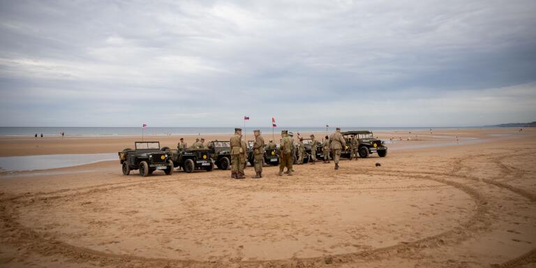 02 June 2019, France (France), Colleville-Sur-Mer: Men from Slovenia stand on Omaha Beach with their historic jeeps and in US uniforms. 06.06.2019 is the 75th anniversary of the landing of allied troops in Normandy (D-Day). Photo: Kay Nietfeld/dpa (Photo by Kay Nietfeld/picture alliance via Getty Images)