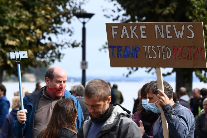 Un manifestant brandit une pancarte portant l’inscription « Désinformation - Trump testé positif » pour protester contre les masques et les restrictions liées au virus lors de la pandémie actuelle de Covid-19, à Constance, le 3 octobre 2020.