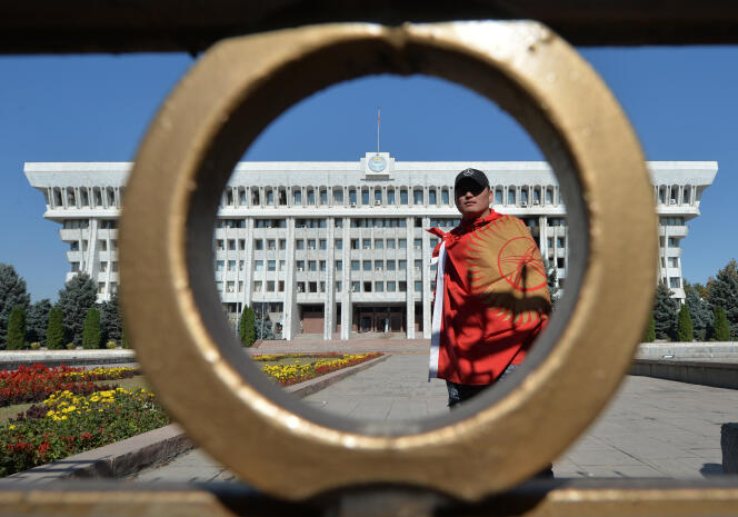 Un manifestant monte la garde devant les bureaux centraux du gouvernement, le 7 octobre, à Bichkek.