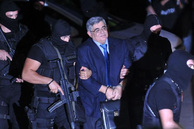 Le secrétaire général du parti néonazi Aube dorée, Nikolaos Michaloliakos, escorté par des policiers, le 2 octobre 2013.