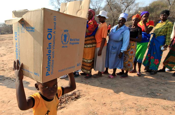 Un enfant porte des rations du Programme alimentaire mondial (PAM), à Mwenezi, au Zimbabwe, le 9 septembre 2015.