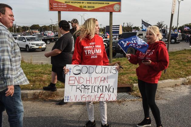 Une femme porte un panneau Qanon en marge d’un meeting pro-Trump, le 11 octobre à Ronkonkoma, dans l’état de New York.