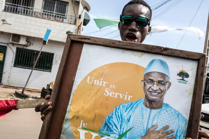Un partisan brandit une affiche de campagne de l’ancien premier ministre de Guinée Cellou Dalein Diallo, à Conakry, le 12 octobre 2020. 