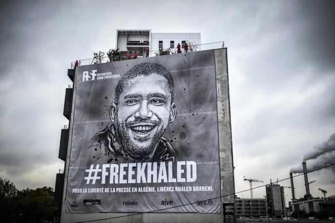 Une bâche représentant le journaliste algérien emprisonné Khaled Drareni, peinte par l’artiste urbain français C215, a été déployée à Paris par Reporters sans frontières, le 15 octobre 2020.