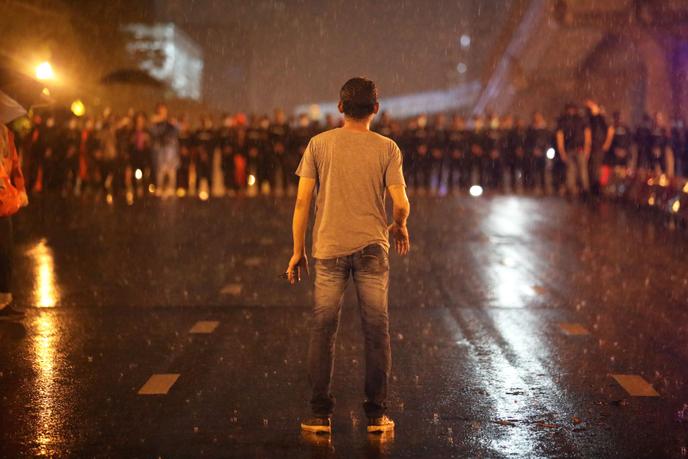 Un manifestant face aux policiers, à Bangkok, le 16 octobre.