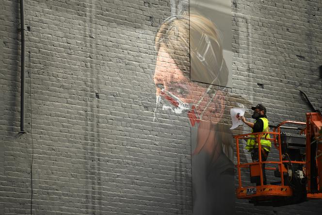 An artist paints a work representing a nurse who is mobilized during the covid-19 pandemic.  North Manchester on 16 October 2020. 