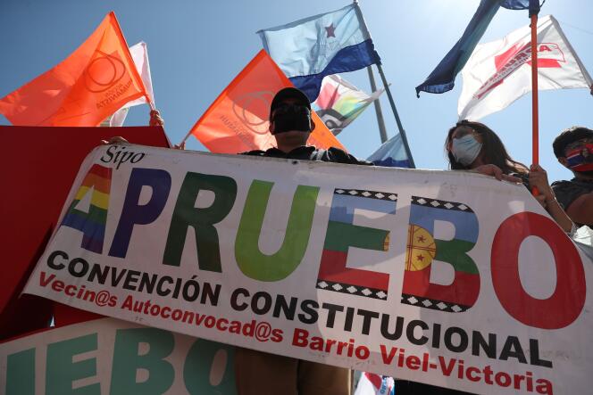 Un militant tient une banderole « J’approuve », à Santiago du Chili, le 22 octobre.