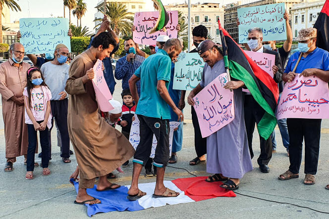 Des manifestants piétinent un drapeau national français lors d’un rassemblement protestant contre les commentaires du président français Emmanuel Macron sur les caricatures du prophète Mahomet, sur la Place des Martyrs de la capitale libyenne, Tripoli, le 25 octobre.