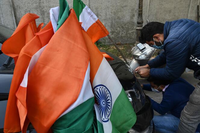 Un militan du BJP, le parti nationaliste hindou au pouvoir en Inde, dispose le drapeau national pour décorer une voiture avant une manifestation à Srinagar, dans le Jammu-et-Cachemire, lundi 26 octobre.