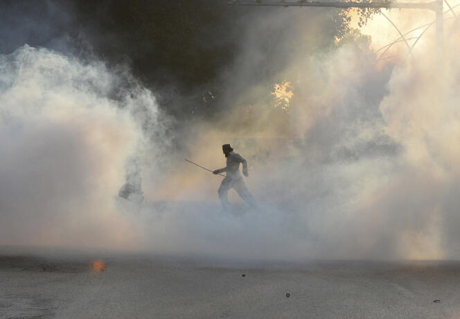A Islamabad, un manifestant court se mettre à l’abri après que la police a tiré des gaz lacrymogènes pour disperser les personnes réunies près de l’ambassade de France, vendredi 30 octobre 2020.