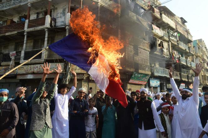 Des musulmans sunnites pakistanais brûlent un drapeau français lors d’une manifestation à Karachi le 30 octobre 2020.