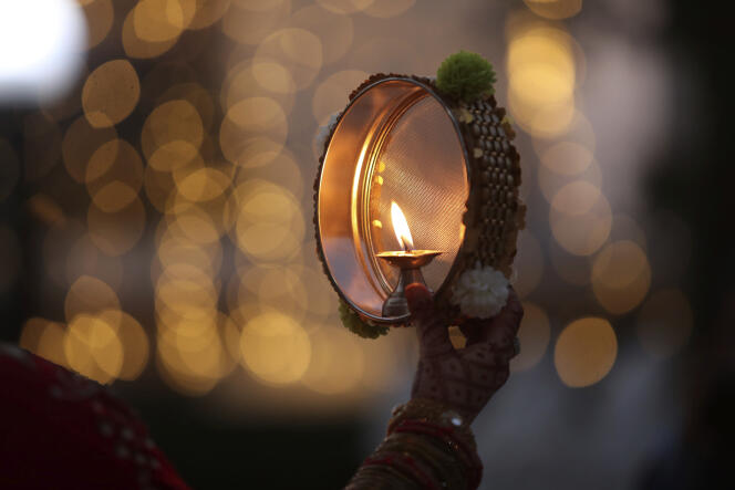 Une femme hindoue réalise un rituel pendant la célébration de Karwa Chauth, Jammu, Inde, novembre 2020.
