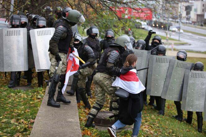 Une femme portant l’ancien drapeau rouge et blanc de la Biélorussie emmenée par les forces de l’ordre durant une manifestation antigouvernementale à Minsk, en Biélorussie, le 8 novembre 2020.