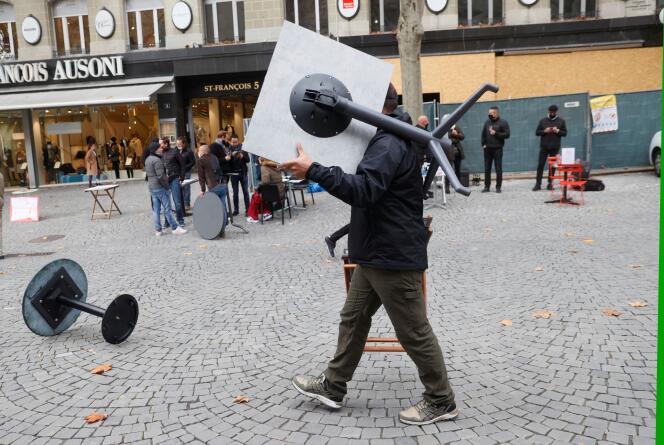 Un homme range une table de bistrot après une protestation des cafés et restaurants contre leur fermeture dans le cadre des mesures prises pour stopper le coronavirus, à Lausanne, le 10 novembre.
