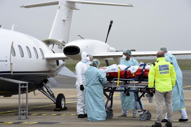 Le personnel médical du SMUR de Lille prend en charge un patient atteint du Covid-19 de l’hôpital de Roubaix pour un transfert vers l’hôpital de Münster, dans le nord de l’Allemagne, à l’aéroport de Lille-Lesquin, dans les Hauts-de-France, le 10 novembre.