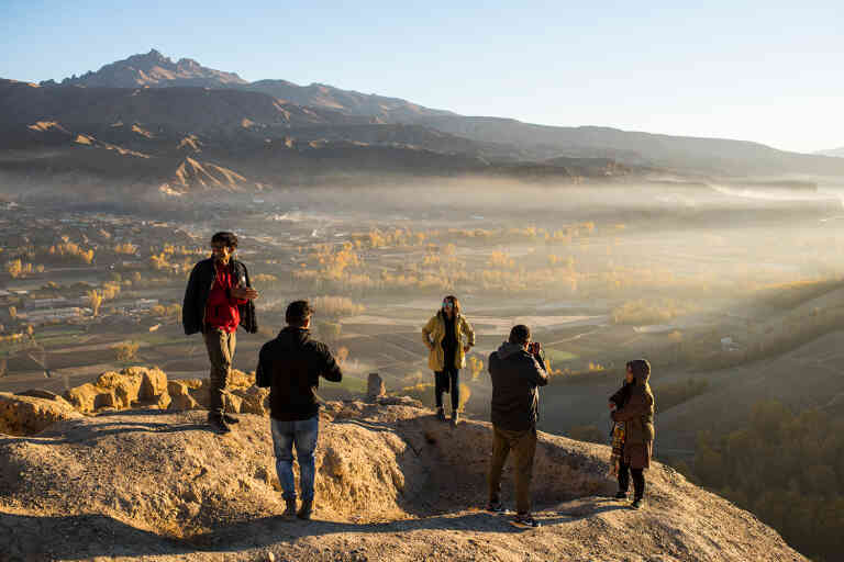 Young men and women, some from Kabul and others from Bamiyan, take photos of one another at Gholghola, and ancient fort city, as the sunrises over the Bamiyan Valley.