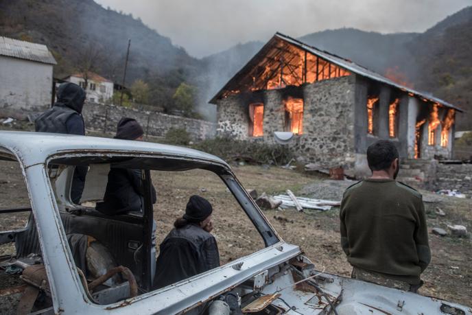 Une famille regarde sa maison qu'elle vient de mettre en feu avant de la quitter, Dadivank, Haut-Karabakh, le 12 novembre.