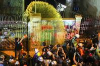 Un manifestant prodémocratie vide un pot de peinture sur la façade du quartier général de la police, à Bangkok, mercredi 18 novembre.